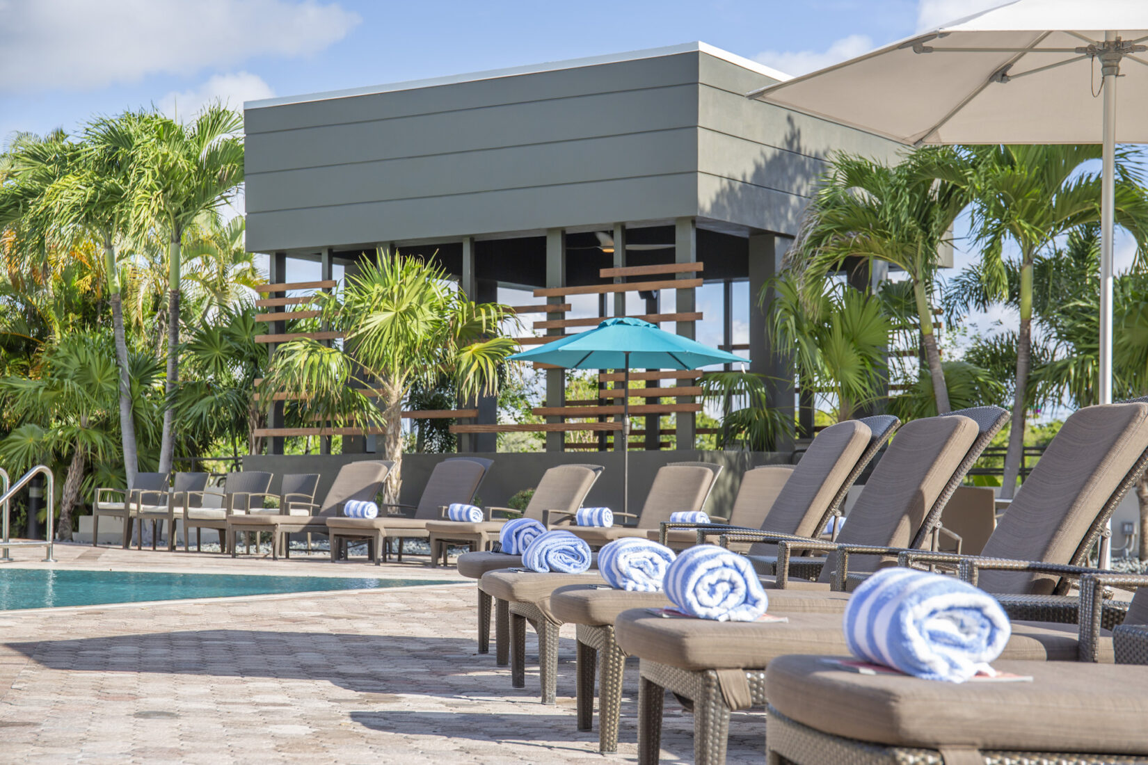 Hotel pool deck with folded towels on each lounge chair