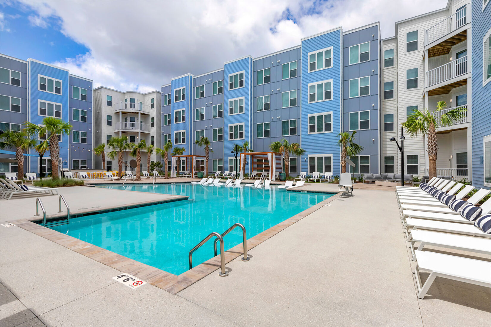 Apartment Community Pool with White Lounge Chairs