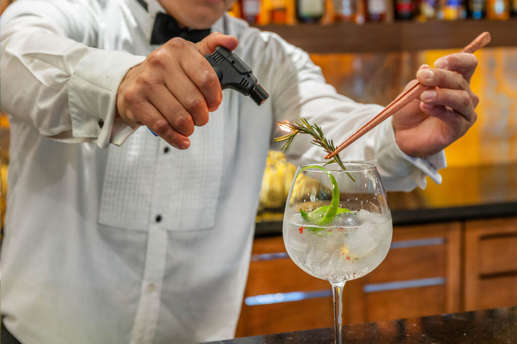 Omni Bar Bartender Lighting Rosemary on Fire to Make Drink