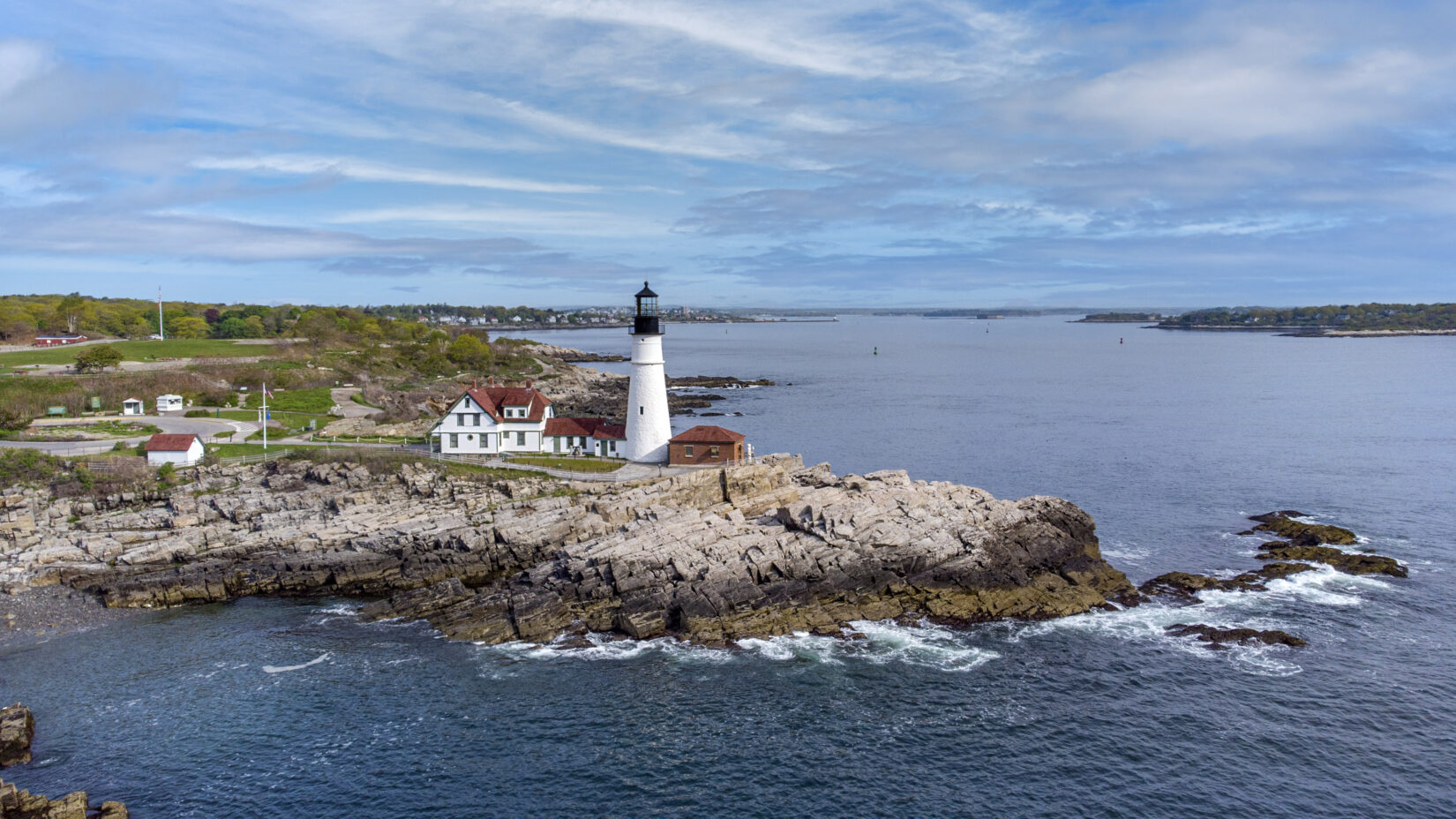 Aerial photo of Portland lighthouse and water from afar. Real estate photography Portland.