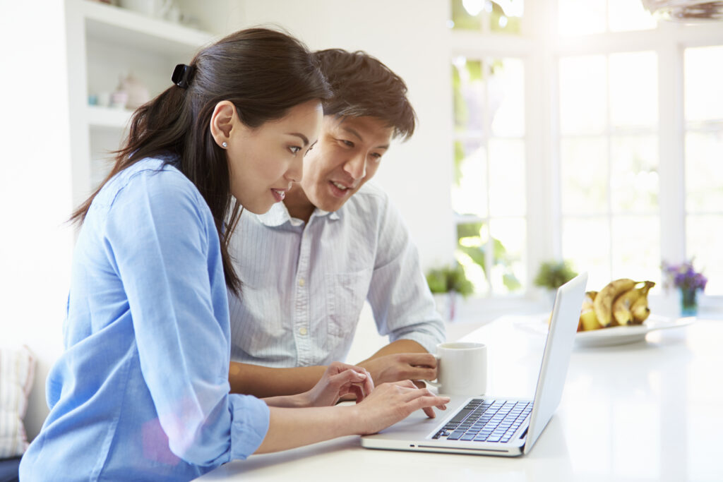 Couple looking at laptop in kitchen