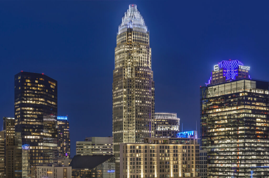 A view of downtown Charlotte skyscrapers lit up at night.