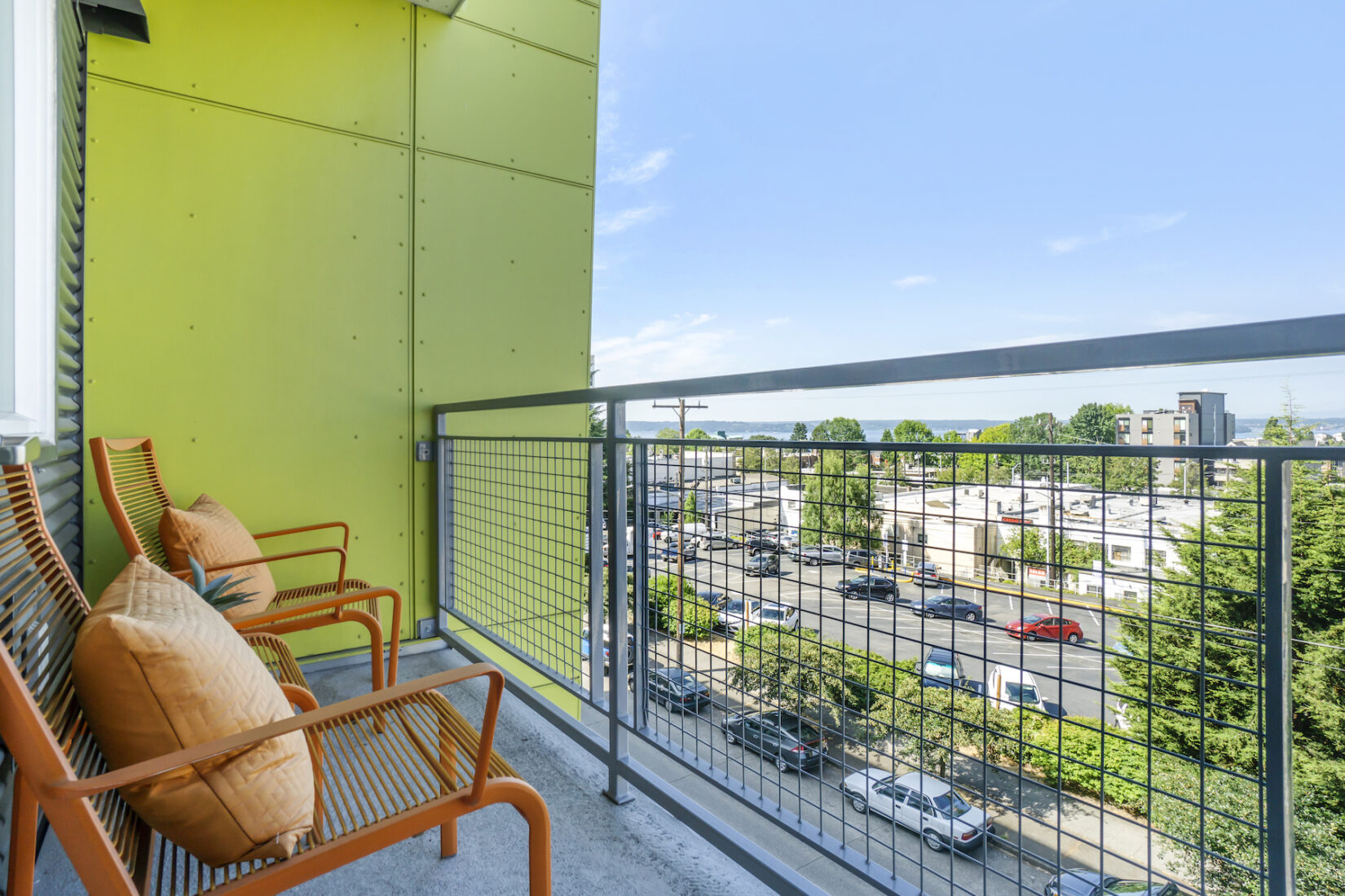 The balcony of a Portland multifamily complex decorated with patio chairs.
