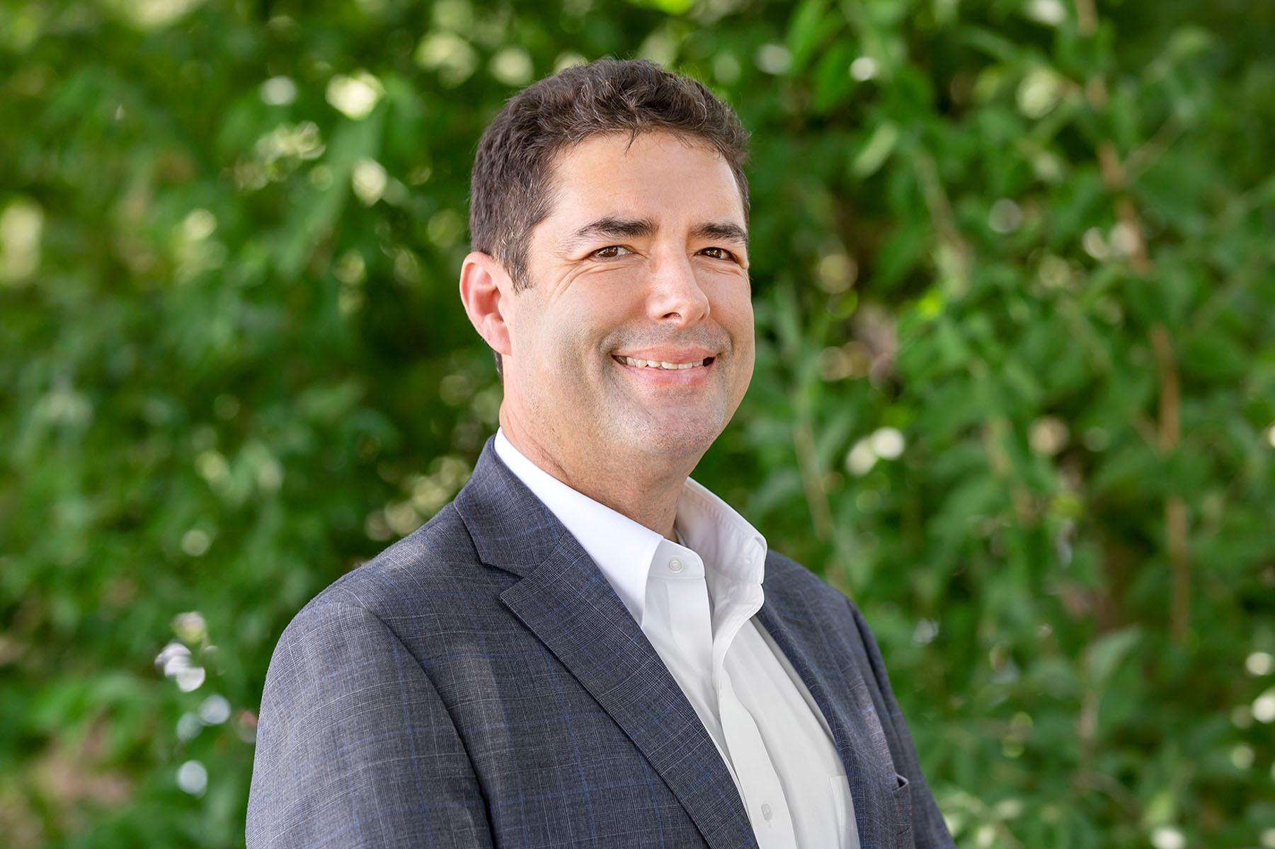  A headshot of a man with brown hair in a grey suit. How to choose a headshot photographer.