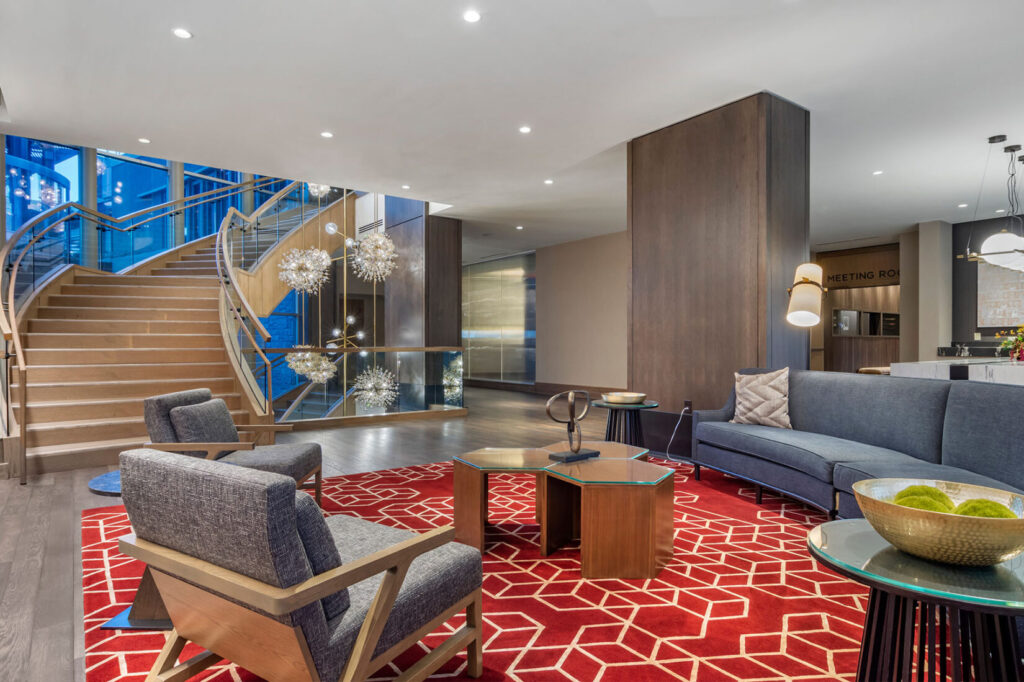 Omni Hotel at the Battery in Atlanta's lobby featuring a curved staircase, lounge seating, and modern lighting.