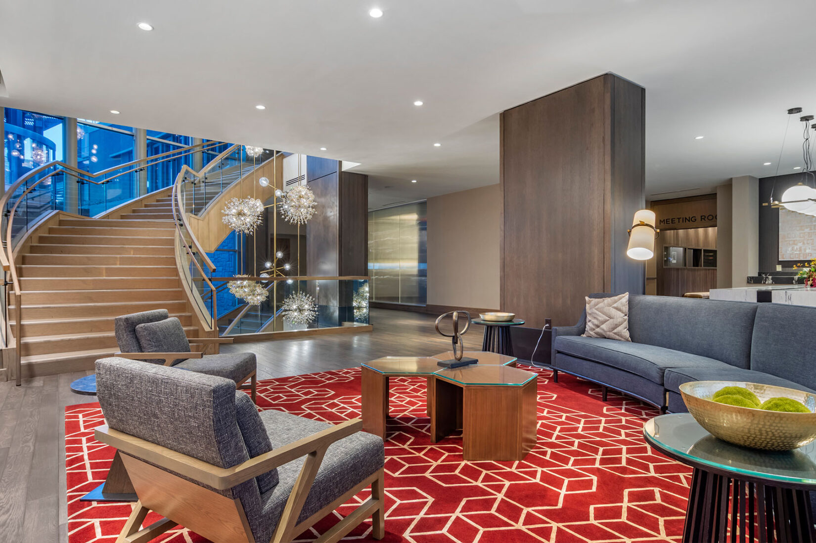 Omni Hotel at the Battery in Atlanta's lobby featuring a curved staircase, lounge seating, and modern lighting.